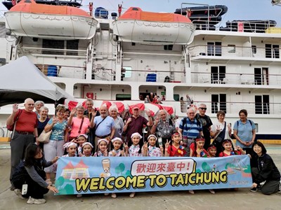 國際遊客與本市迎賓表演小朋友合影